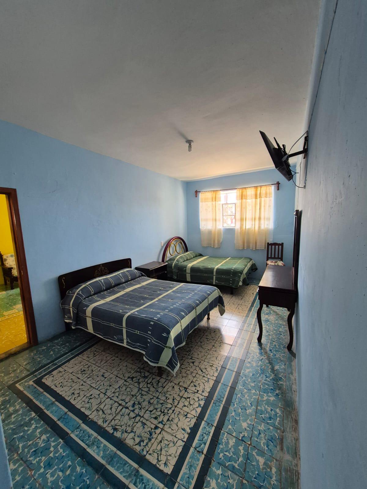 Habitación con dos camas y luz natural