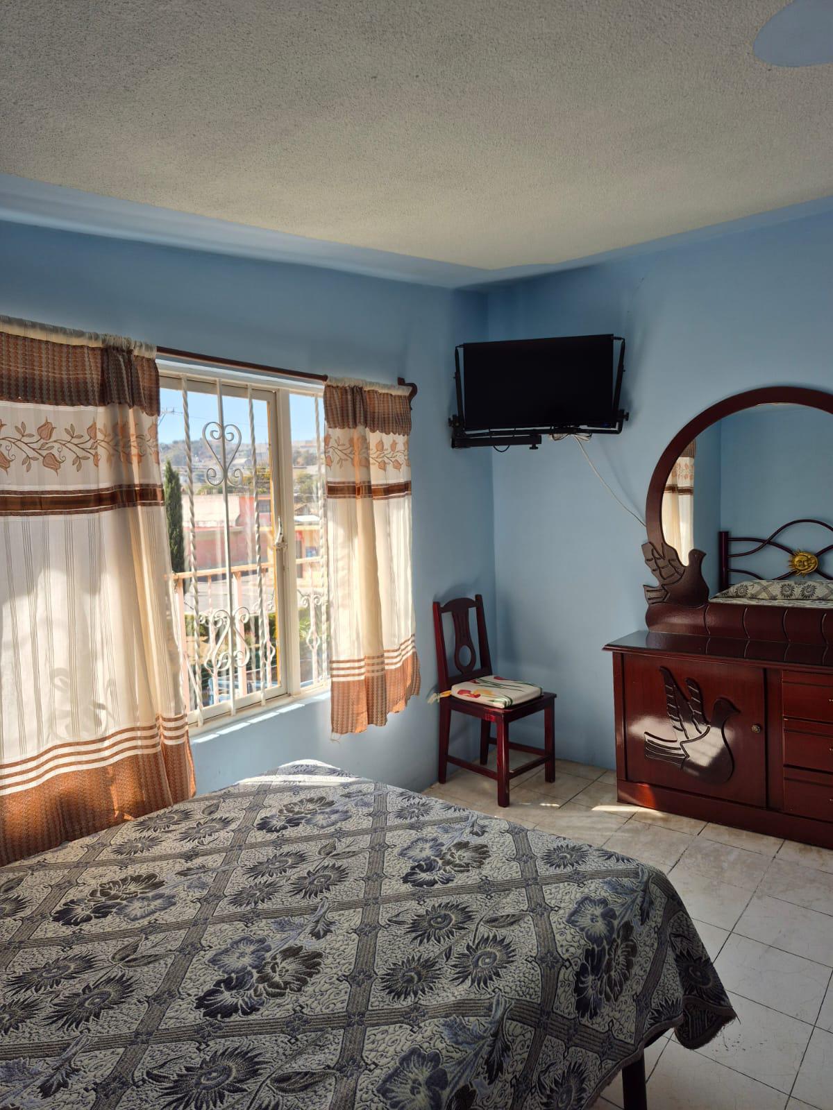 Habitación con cama matrimonial y televisión